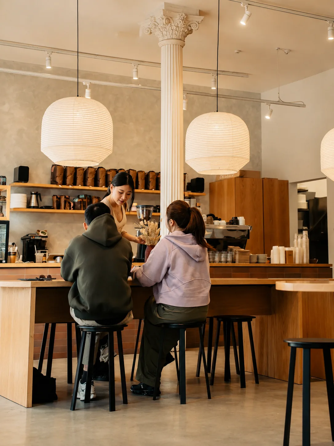 Customers seated at the Akin Cafe counter beneath paper lanterns