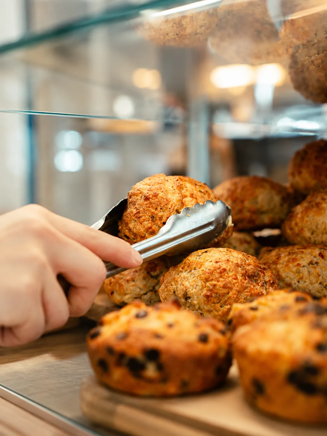Fresh cabinet baking being selected at Akin Cafe