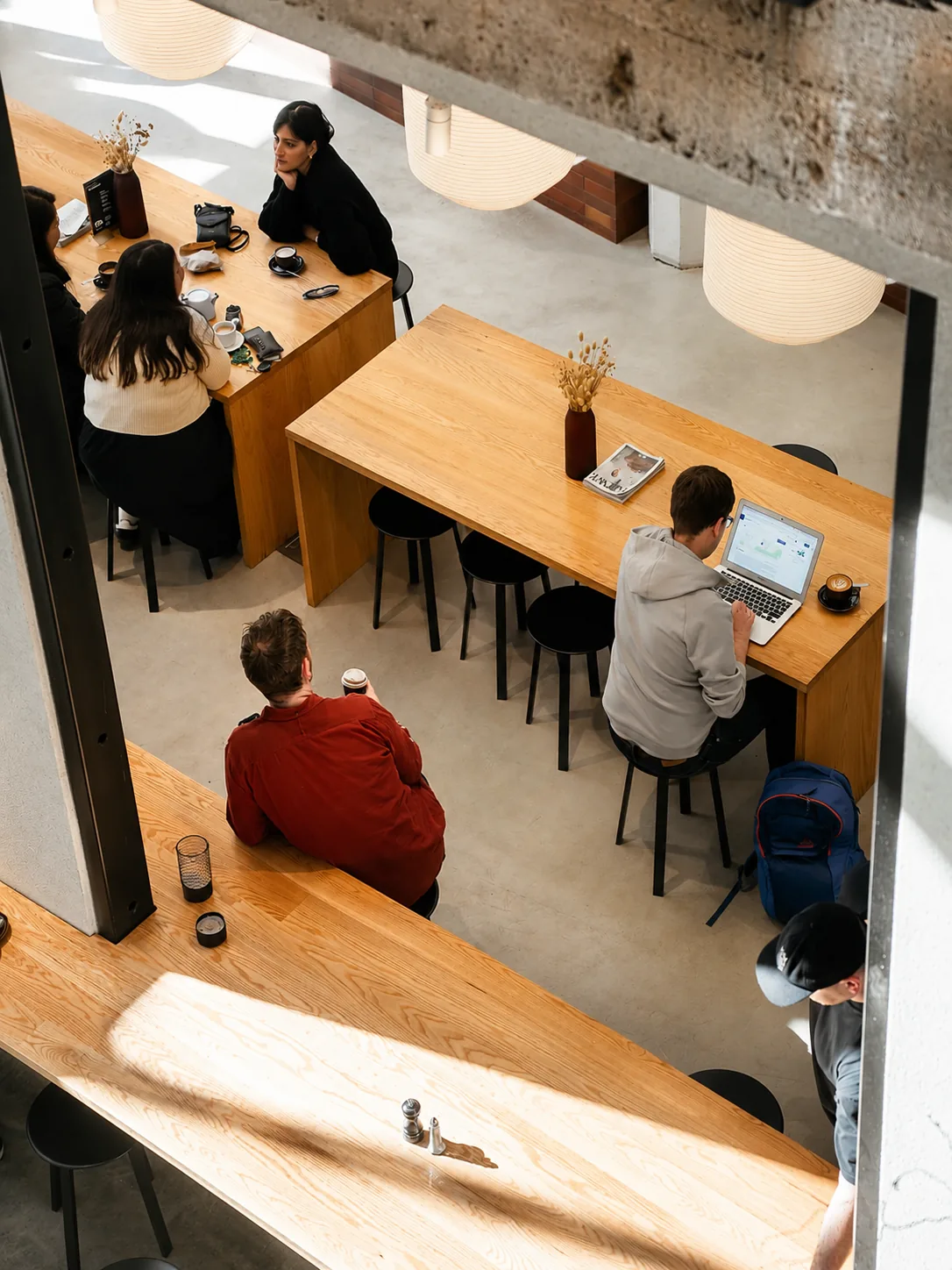 Guests working and catching up at timber tables inside Akin Cafe